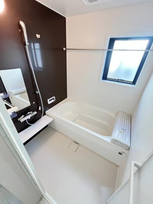 白を基調とした明るいバス空間です。大きめの窓が設置されており換気もしやすく快適に利用できます。壁面のカラーアクセントがスタイリッシュな印象を与えます。
