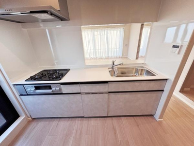 スタイリッシュで清潔感のあるキッチンです。シンプルなデザインでお手入れも簡単。使いやすいシンクとコンロが並び作業動線に配慮されています。調理スペースも広めに確保されています。