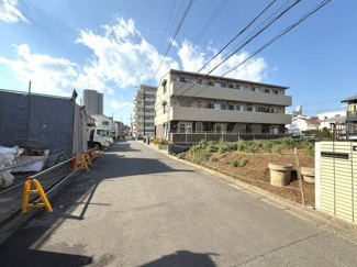 道路幅が広くすっきりとした印象の街並みです。日当たりの良いエリアで空が広く感じられます。近くにマンションや住宅が建ち並び落ち着いた雰囲気です。周囲には整ったインフラが整備されています。