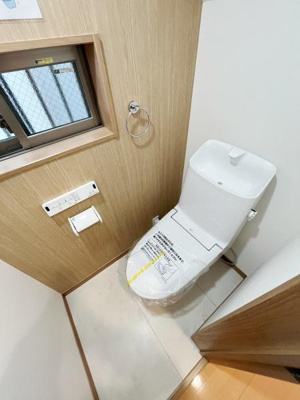 窓付きで換気しやすいトイレです。シンプルなデザインで清潔感があります。ペーパーホルダーやタオルリングも備わっています。スペースに無駄がなく使いやすい配置です。床もお手入れしやすい素材です。