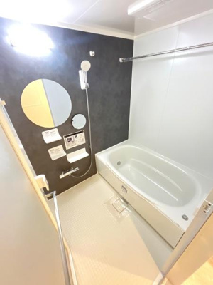 浴槽とシャワーが独立した使いやすいバス空間です。清潔感のある白を基調としたデザインが印象的です。壁面の丸いミラーがアクセントとなっています。床もお手入れしやすい仕様です。