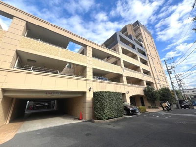 開放感のある外観が特徴的なマンションです。重厚感のあるデザインが印象的です。敷地内にはゆとりある駐車スペースが確保されています。青空が広がる環境に建つ建物です。