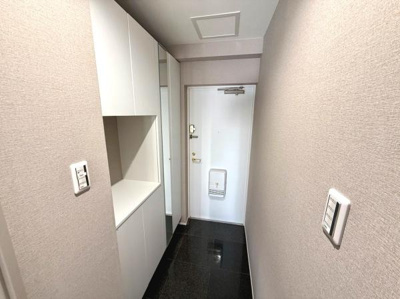 白を基調とした玄関で明るく清潔感のある印象です。収納スペースが豊富に設けられており使い勝手も考えられています。床材の質感が高く落ち着いた雰囲気を演出しています。