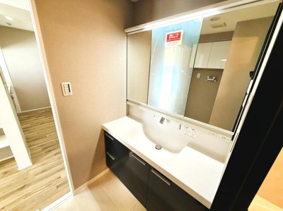 広々としたカウンターが特徴の洗面台です。大きな鏡が空間をより明るく感じさせます。収納スペースも豊富で日用品の整理がしやすいデザインです。