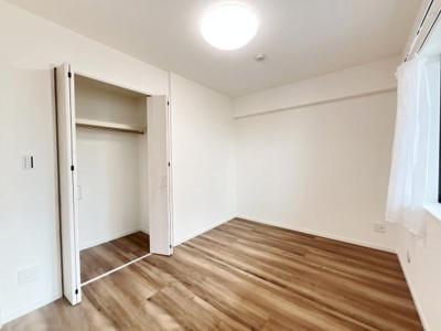 明るい照明が印象的な洋室です。大きな窓から自然光が差し込み室内が開放的に感じられます。クローゼットは使いやすい折れ戸仕様で収納力があります。