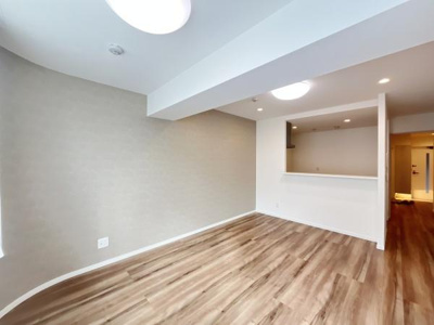 明るいフローリングと白を基調とした壁がリビング全体を広々とした印象にしています。開放感のある間取りが魅力的です。キッチンカウンターが配置されており空間がすっきりしています。