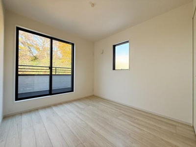 大きな窓からたっぷりと自然光が差し込む洋室です。シンプルな内装が広々とした空間を演出しています。フローリングの明るい色合いが部屋全体を爽やかに見せています。