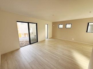 大きな窓から光が差し込む明るいリビングです。ナチュラルなフローリングが開放感を引き立てます。シンプルな内装で幅広いインテリアに対応できます。バルコニーへのアクセスも便利です。