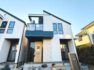 シャープな外観デザインが印象的な戸建住宅です。バルコニー付きで様々な用途に対応可能。窓の配置が特徴的で採光にも配慮されています。周囲には落ち着いた雰囲気の住宅が並んでいます。