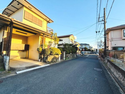 前面道路が広々としており車の出入りも安心です。周囲には落ち着いた住宅が並び静かな雰囲気が漂っています。日当たりの良さが魅力で明るい印象の現地写真となっています。