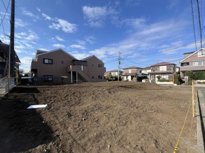 広々とした現地土地写真です。周囲には住宅が立ち並び開放感を感じられます。道路に面しているためアクセスも便利です。日当たりの良さが魅力的な土地となっています。